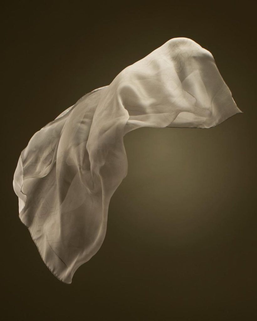 flowing sheer silk fabric on dark background